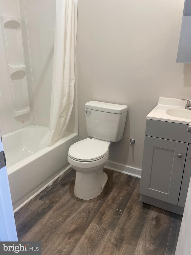 full bathroom featuring shower / bathtub combination with curtain, toilet, vanity, and hardwood / wood-style floors