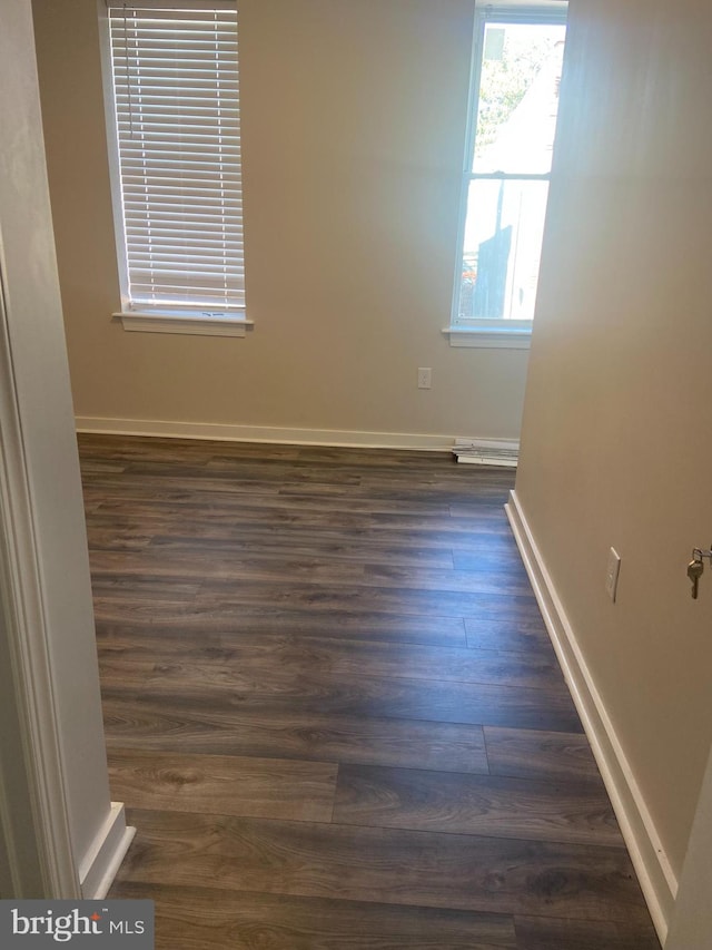 unfurnished room with dark hardwood / wood-style flooring