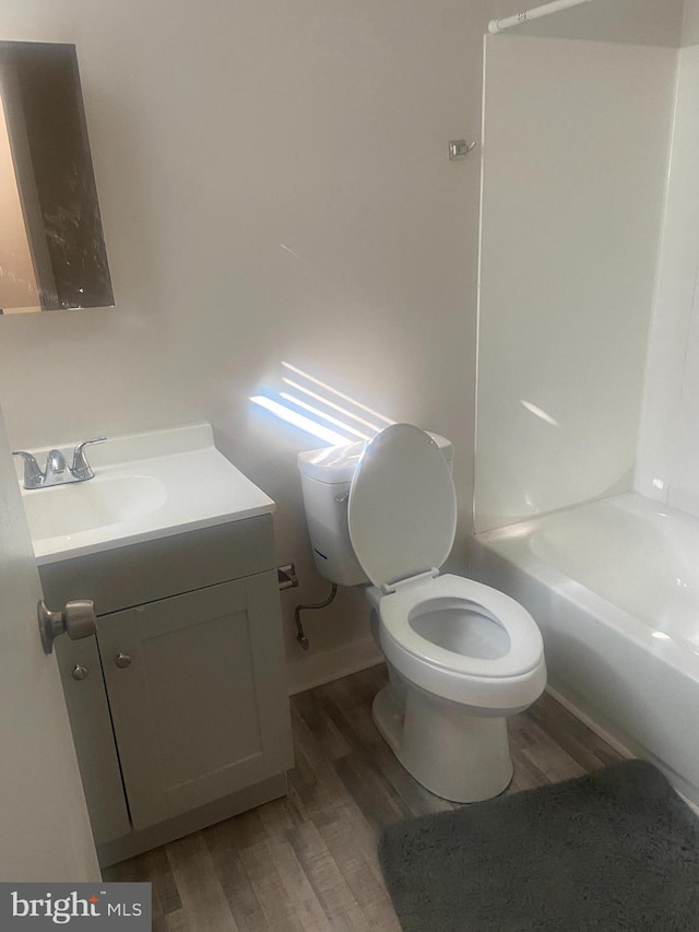 full bathroom with vanity, hardwood / wood-style flooring, toilet, and bathing tub / shower combination