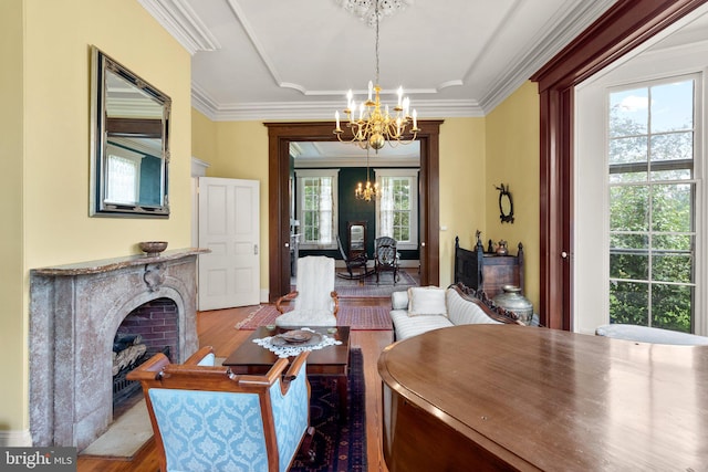 dining space featuring a high end fireplace, an inviting chandelier, crown molding, and hardwood / wood-style floors