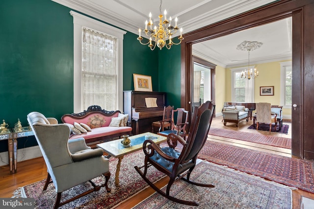 living room with crown molding, a notable chandelier, and hardwood / wood-style flooring