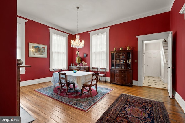 tiled dining area with ornamental molding and a chandelier