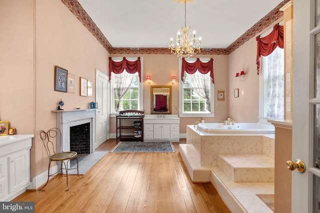 bathroom featuring tiled bath, hardwood / wood-style flooring, and vanity