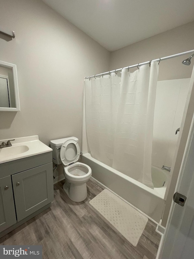 full bathroom with wood-type flooring, vanity, toilet, and shower / bathtub combination with curtain