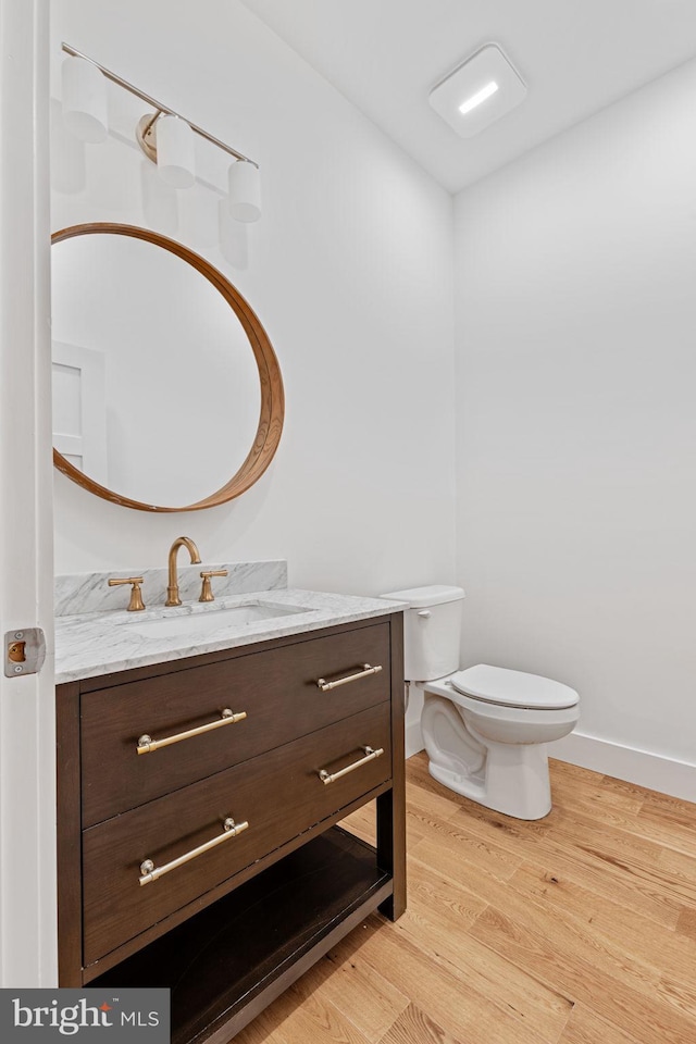 bathroom with vanity, hardwood / wood-style floors, and toilet