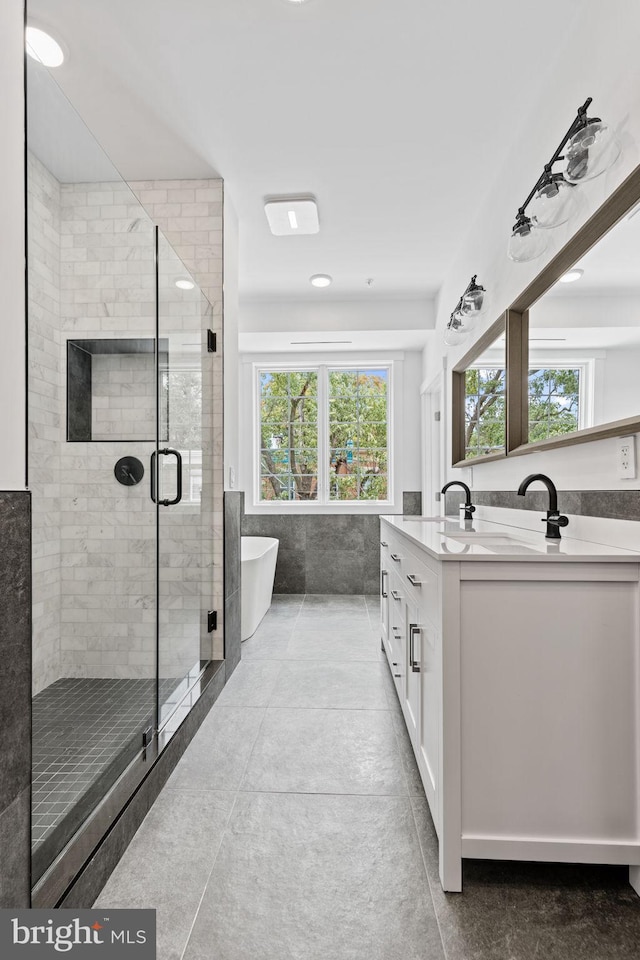 bathroom with vanity, shower with separate bathtub, a healthy amount of sunlight, and tile patterned flooring