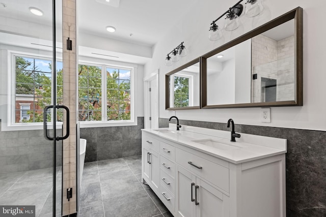 bathroom with tile walls, vanity, walk in shower, and plenty of natural light