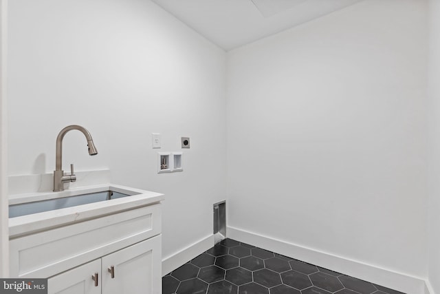 clothes washing area featuring cabinets, washer hookup, dark tile patterned floors, electric dryer hookup, and sink