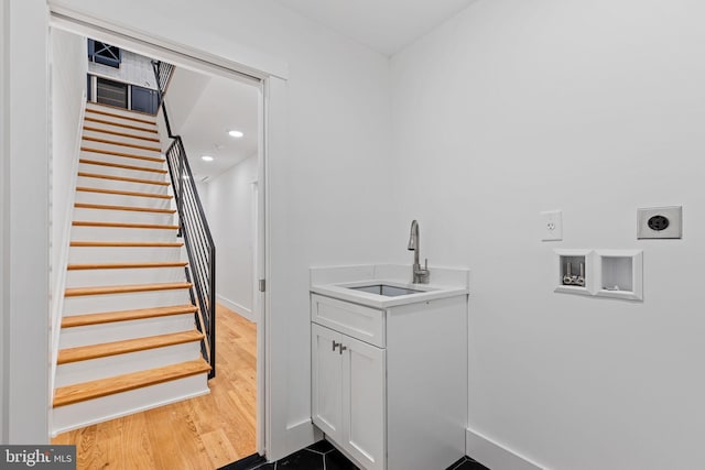 washroom featuring hardwood / wood-style floors, hookup for an electric dryer, sink, and washer hookup