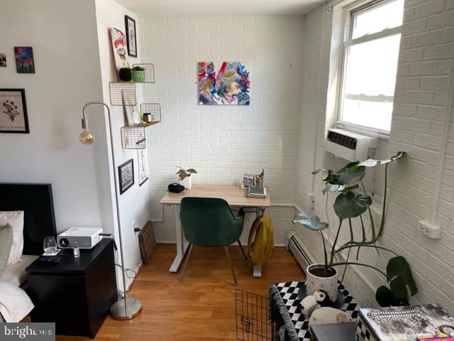 office area featuring brick wall and light wood-type flooring