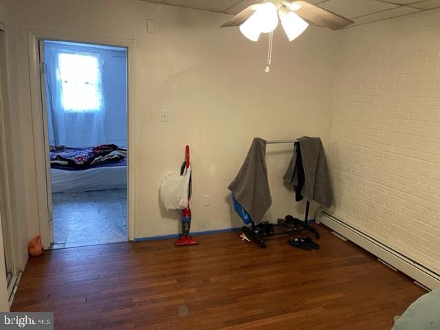 misc room featuring ceiling fan, a baseboard radiator, and dark wood-type flooring