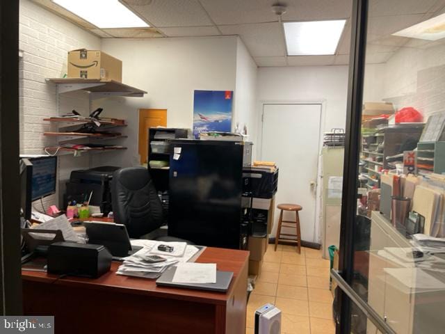 office space featuring a drop ceiling and light tile floors