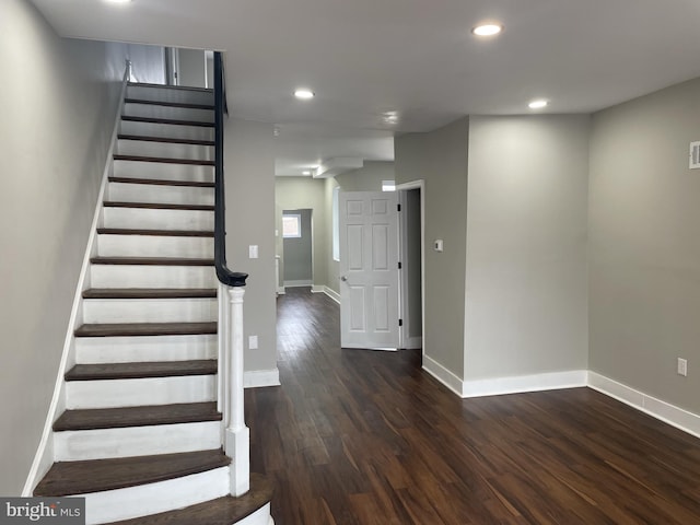 stairs with dark hardwood / wood-style floors