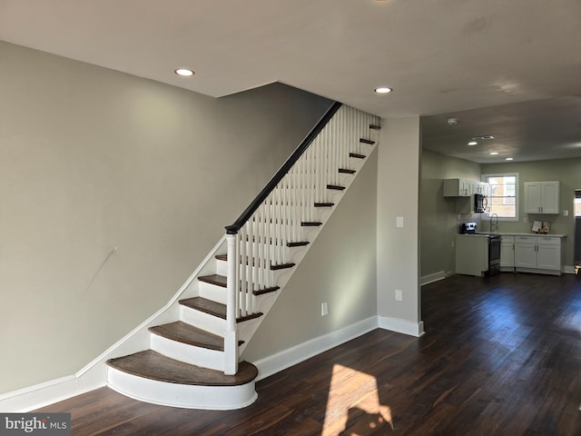 stairs with sink and dark hardwood / wood-style flooring