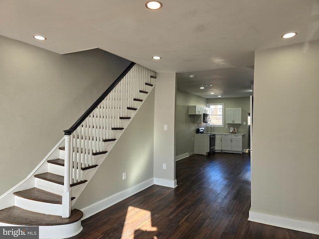 stairs with dark wood-type flooring and sink