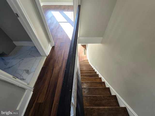 stairway featuring dark tile flooring