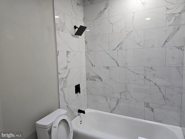 bathroom with toilet and tiled shower / bath