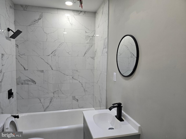 bathroom featuring large vanity and tiled shower / bath