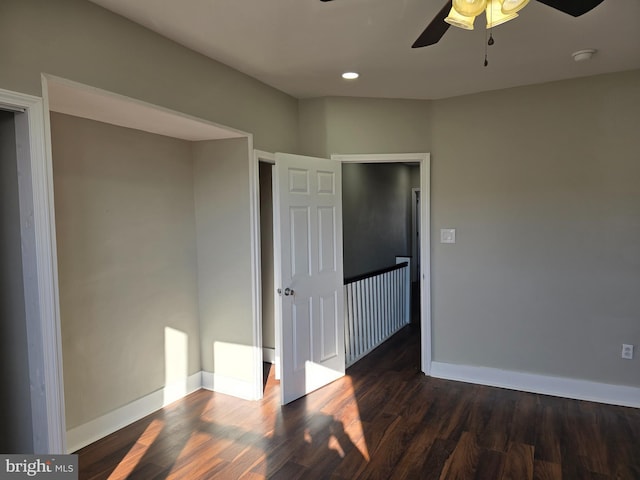 unfurnished bedroom with dark hardwood / wood-style flooring and ceiling fan