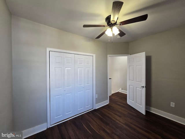 unfurnished bedroom with a closet, dark hardwood / wood-style floors, and ceiling fan