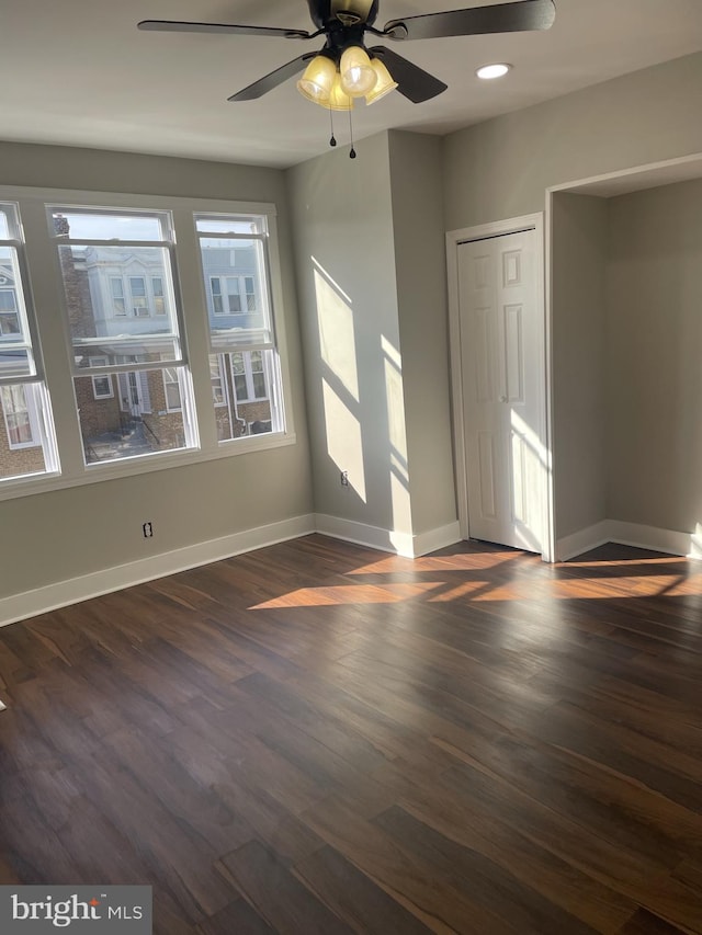 empty room featuring ceiling fan and dark wood-type flooring