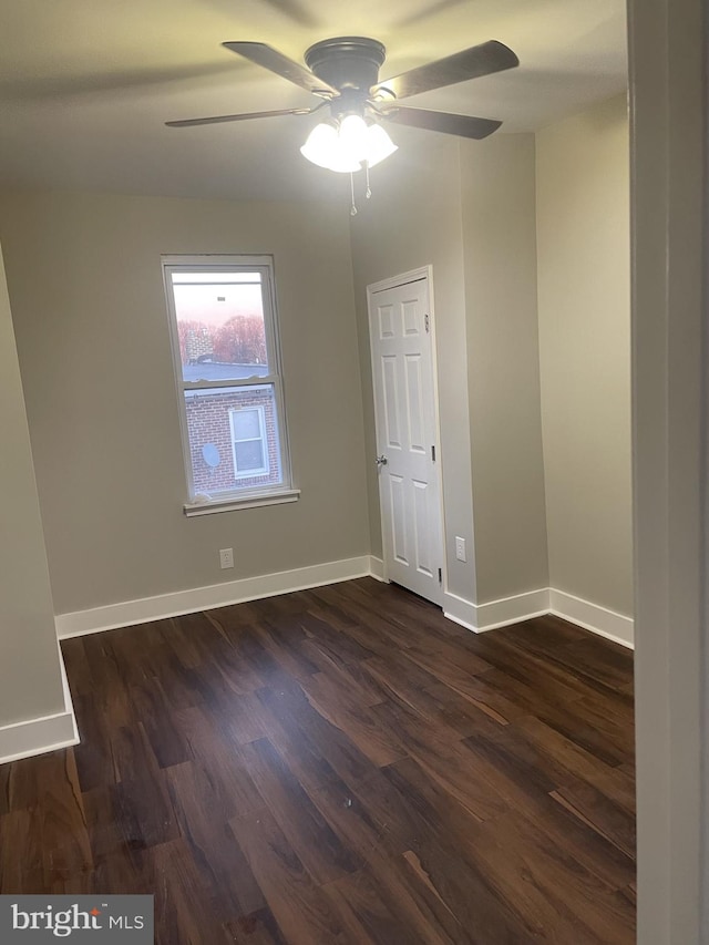 spare room featuring dark hardwood / wood-style flooring and ceiling fan