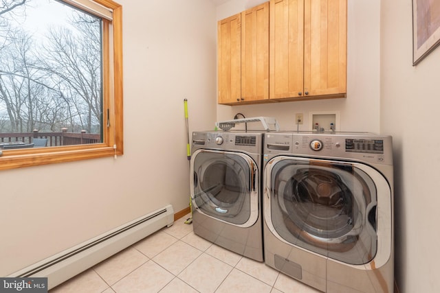 washroom featuring washing machine and clothes dryer, a baseboard heating unit, light tile patterned flooring, and plenty of natural light