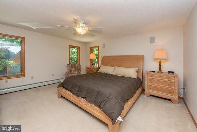 bedroom with a baseboard radiator, ceiling fan, a textured ceiling, and multiple windows