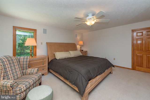 carpeted bedroom featuring a textured ceiling and ceiling fan