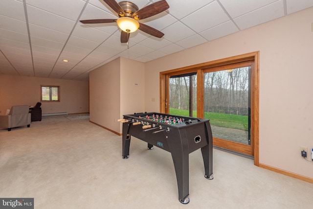 game room featuring light carpet, a drop ceiling, baseboard heating, and ceiling fan