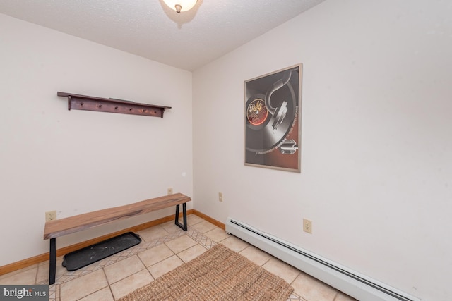 interior space featuring a textured ceiling, baseboard heating, and light tile patterned flooring