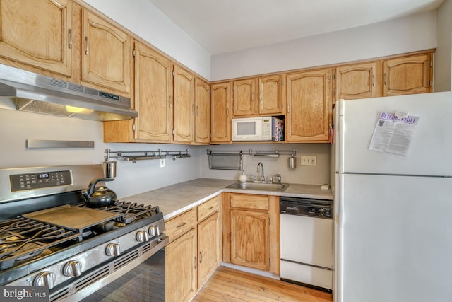 kitchen featuring white appliances, sink, and light wood-type flooring