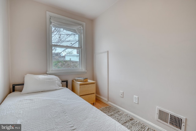 bedroom featuring lofted ceiling and hardwood / wood-style flooring