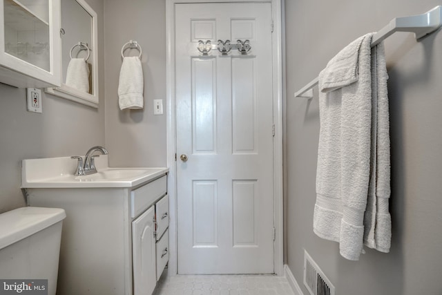 bathroom featuring vanity, toilet, and tile floors