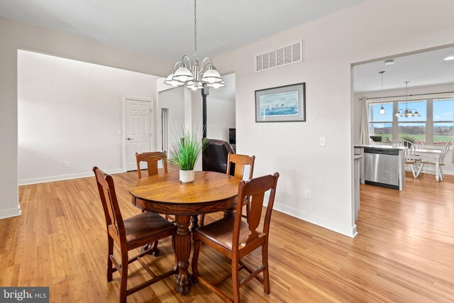 dining space featuring a chandelier and light hardwood / wood-style flooring