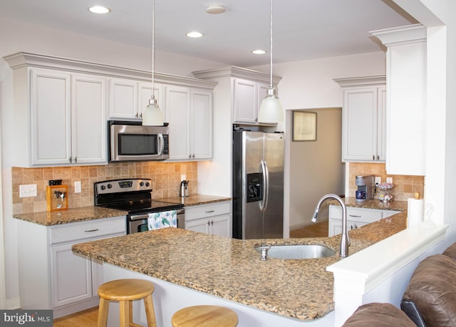 kitchen featuring tasteful backsplash, stainless steel appliances, pendant lighting, and a breakfast bar