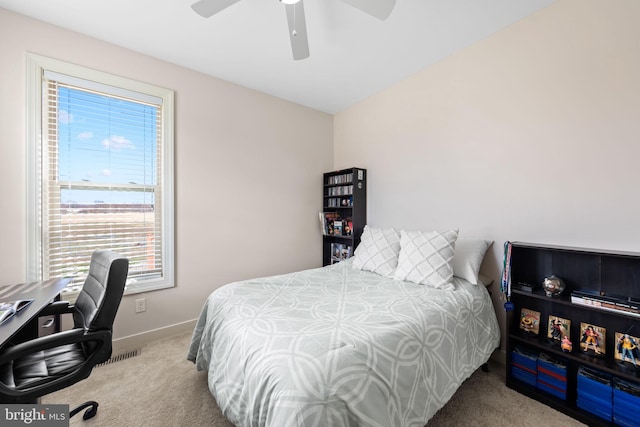 carpeted bedroom featuring ceiling fan and multiple windows