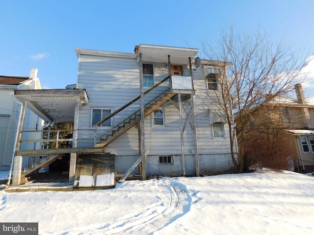 view of snow covered back of property