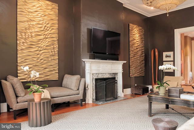 living room featuring a premium fireplace, crown molding, and wood-type flooring