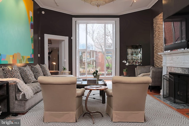 living room featuring ornamental molding, a fireplace, and light hardwood / wood-style flooring