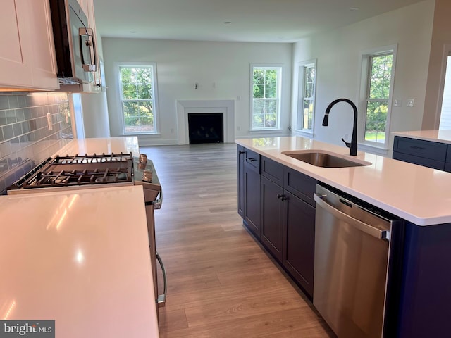 kitchen with appliances with stainless steel finishes, sink, an island with sink, and a wealth of natural light