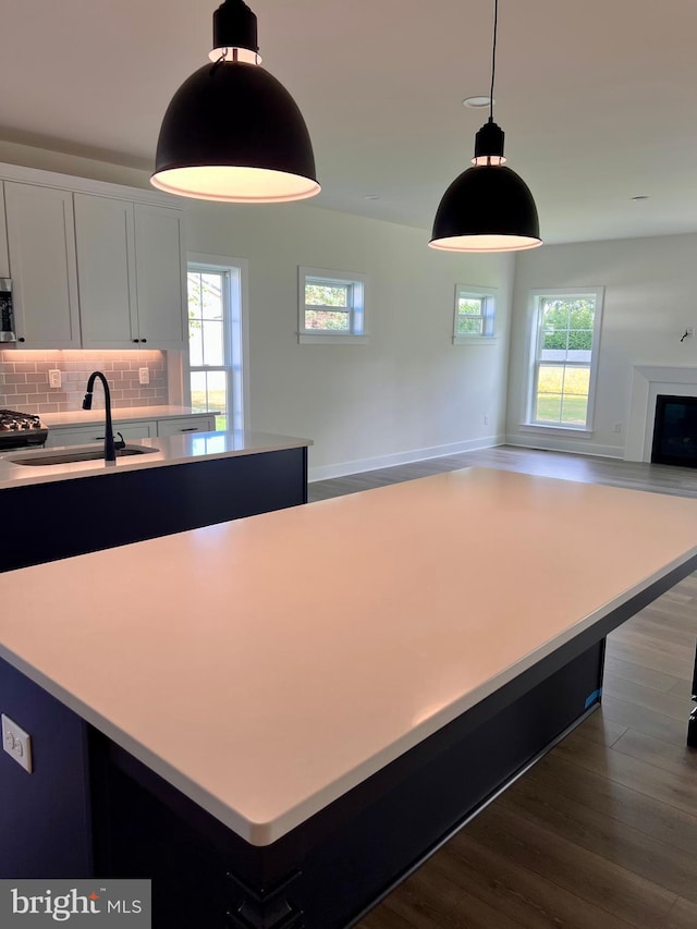 kitchen with a kitchen island, white cabinetry, sink, and plenty of natural light