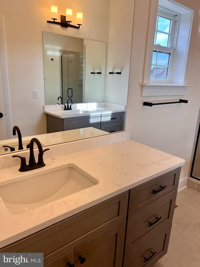 bathroom with tile patterned floors, an enclosed shower, and vanity