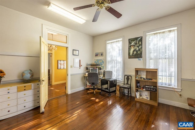 home office with dark hardwood / wood-style floors and ceiling fan with notable chandelier