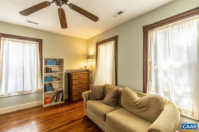 living room featuring ceiling fan and dark wood-type flooring