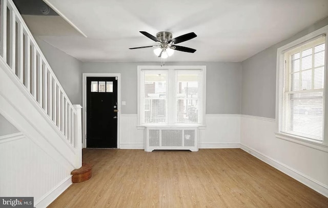 foyer entrance featuring ceiling fan, light hardwood / wood-style floors, and radiator