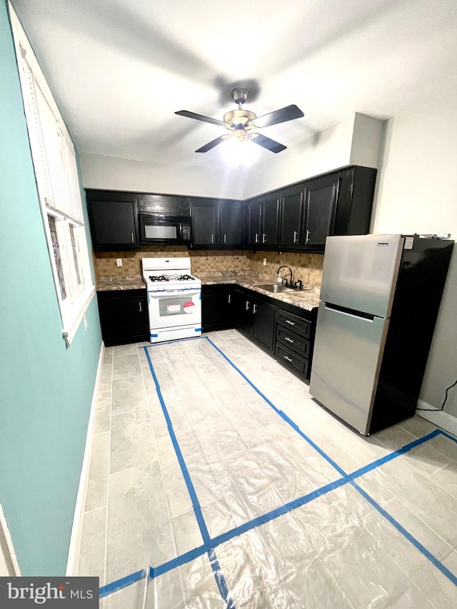 kitchen featuring stainless steel fridge, ceiling fan, backsplash, light tile floors, and white gas range oven