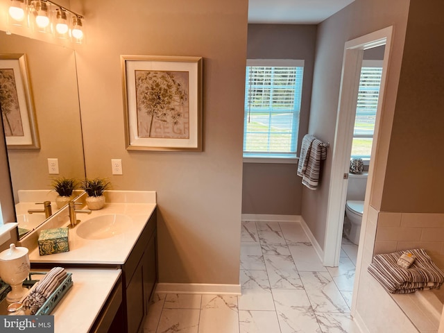 bathroom with toilet, tile floors, and vanity