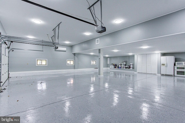 garage featuring white refrigerator with ice dispenser and a garage door opener