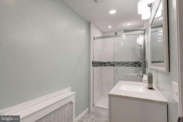 bathroom with tile floors, a shower with shower door, and vanity